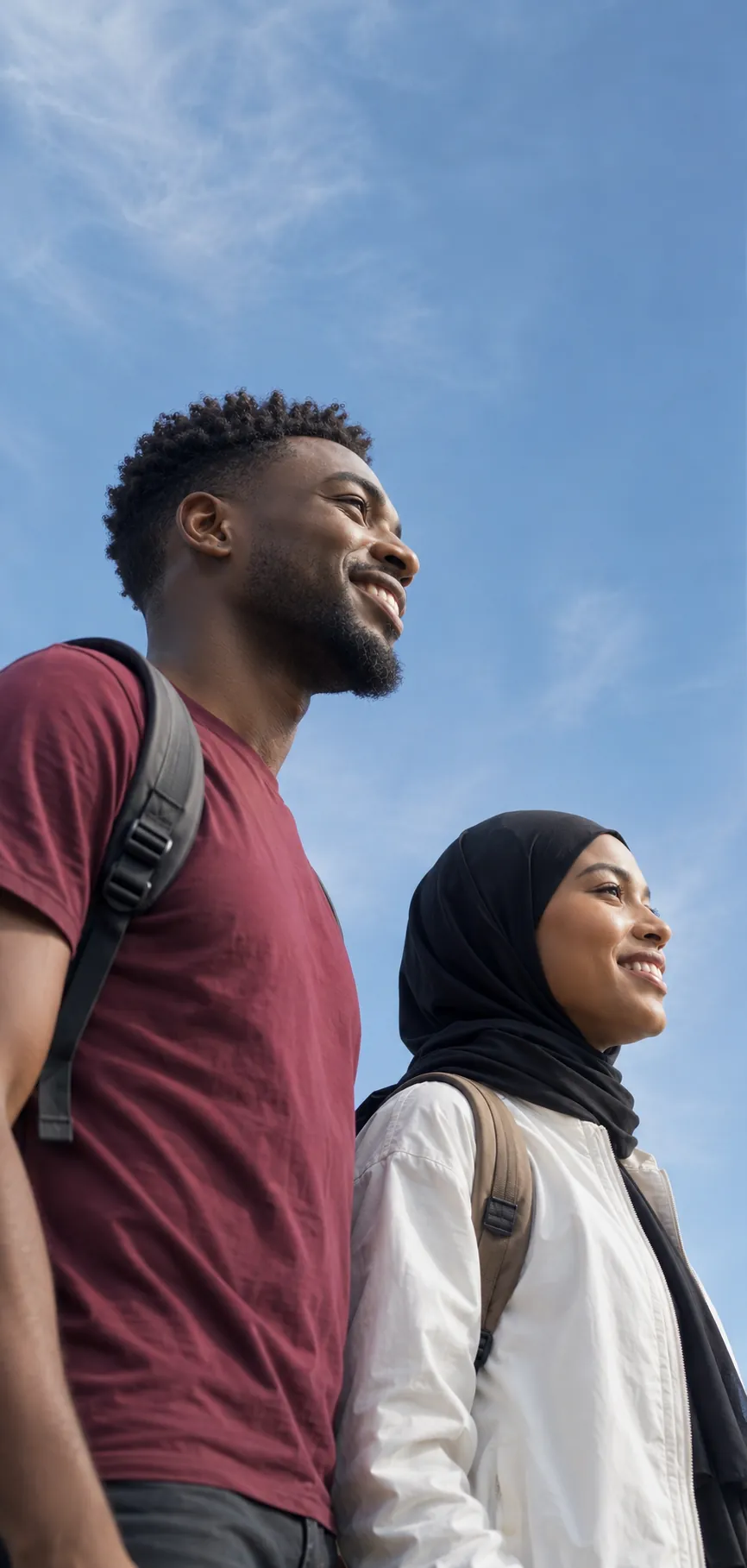 Two community members smiling under a blue sky